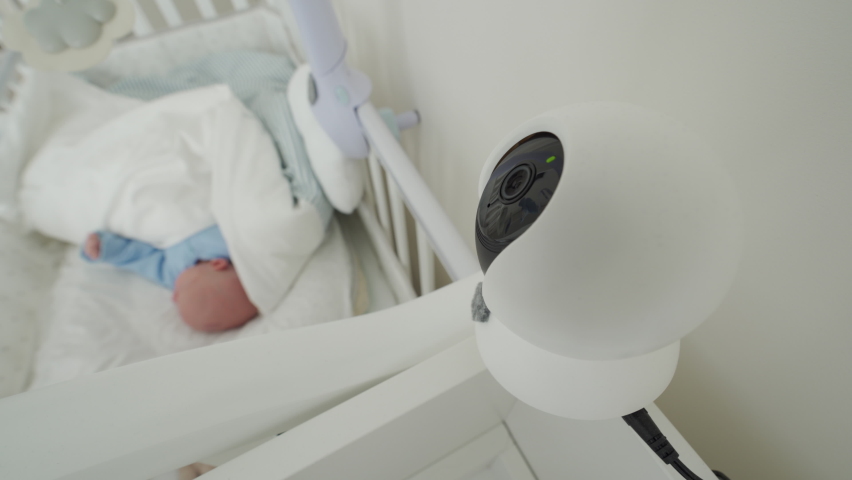 Ip camera as baby monitor camera above the crib in the bedroom, newborn baby boy is sleeping peacefully in bed. High quality 4k footage Royalty-Free Stock Footage #1070254051