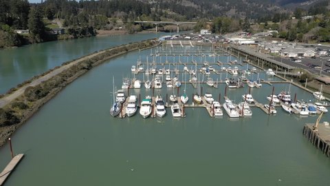 Luxury Ships And Boats Moored On Chetco River At Port Of Brookings Harbor During Daytime In Oregon. - Aerial Tilt-Down Shot