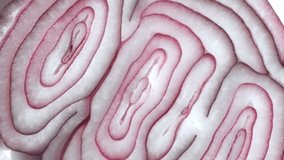 Sliced red onion rings rotating in 4K. Closeup top view of healthy food background with vegetable of rich vitamin