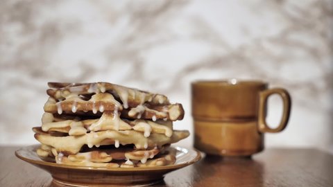Liege waffles close up with condensed milk in super slow mo. Traditional food in Belgium. Breakfast with coffee on marble background. High quality FullHD footage