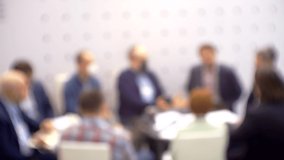 Unrecognizable people who are holding a business meeting or negotiation. Blurry defocused video. Business theme background