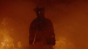 Dramatic shot of American firefighter in full gear walking through smoke away from huge fire. Shot with 2x anamorphic lens  - Powered by Shutterstock - Get 15% off with code: PIKWIZARD15