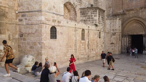 Jerusalem, Israel - July 3, 2019: People in the courtyard of the Church of the Holy Sepulchre, 4k video footage panning right