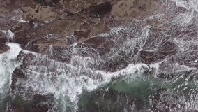 Waves crashing on rocks with white foam