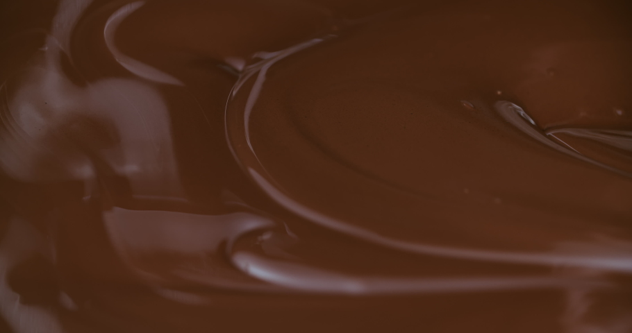 Close-up stirring chocolate with metal pastry spoon, hot melted liquid chocolate, mixing molten milk chocolate or dark caramel. Cooking handmade chocolate dessert and candies. Confectionery Royalty-Free Stock Footage #1070287471