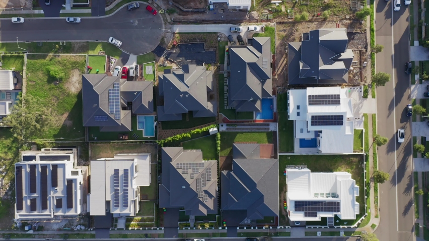 Top down aerial slow sideways fly over modern upmarket houses, some still under construction, most with rooftop solar. Sydney, Australia Royalty-Free Stock Footage #1070291128