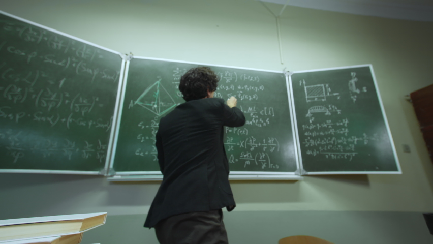 Emotional eccentric teacher trying explain mathematical formulas written in chalk on blackboard in classroom. POV view funny professor emotionally speaking to pupil who does not understand math Royalty-Free Stock Footage #1070301340