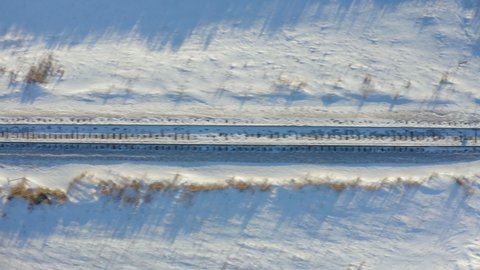 Drone flying over railroad track in Canadian prairie. Empty railway road at winter season. Aerial view