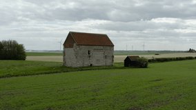 The Chapel of St Peter-on-the-Wall, Bradwell-on-Sea in Essex, England. First part of video is the chapel then the drone flies over it and reveals wind turbines.