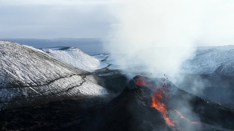 Spatter cone volcano ejecting hot molten magma from earths core, aerial