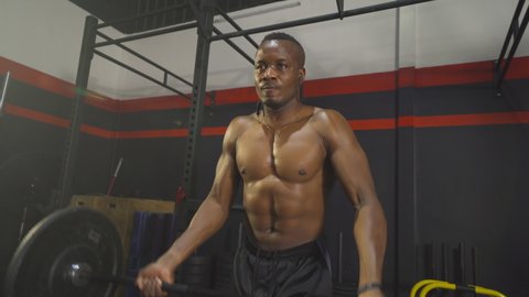 Black African American man lifting sport bar. Muscle strength training workout at gym fitness center club. Exercise indoor with sport equipment. People lifestyle recreation.