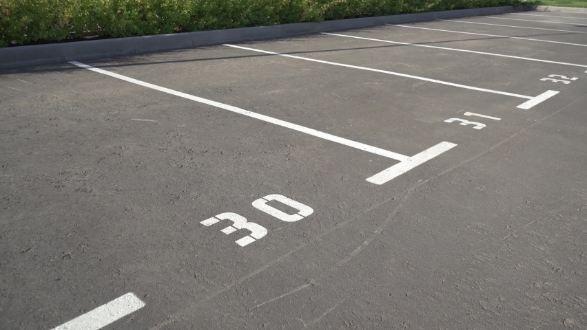 Close-up of a white paint number marking in a parking lot. Empty parking lot, Parking lot with white mark, Open parking in public park. Number 30. Video 4K.