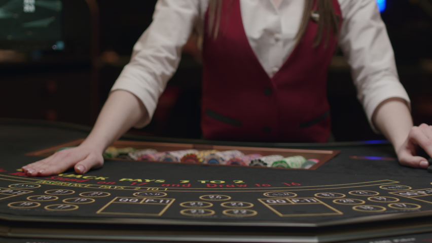 Croupier behind gambling table in a casino. Dealer shuffles the cards. Nightlife Royalty-Free Stock Footage #1070316721