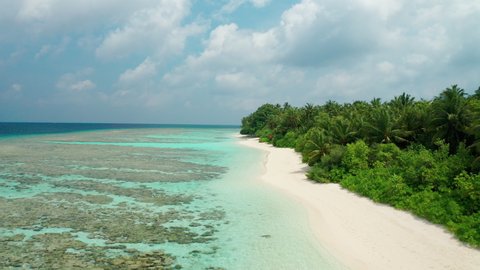 Aerial video of a drone flying over a scenic white sand beach. Thinadhoo (Vaavu Atoll) island in Maldives