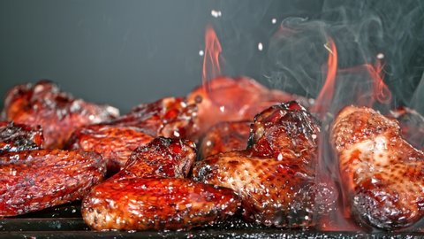 Super Slow Motion Shot of Seasoning Falling on Fresh Grilled Chicken Wings at 1000 fps.