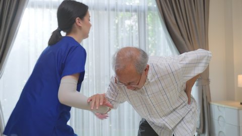 Asian young woman nurse support and help Senior elderly man patient falling down from cane or walker at nursing home care. Caregiver doctor taking care disabled older male. Medical insurance concept.