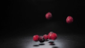 Dried cranberries fall on a black table. Healthy berries, rich in vitamins
