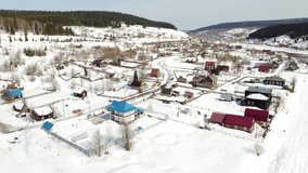 Spring video from a drone flying over a Russian village with wooden houses, the mountain river Usva. Settlement Usva, Perm Territory, Russia, Ural Mountains.