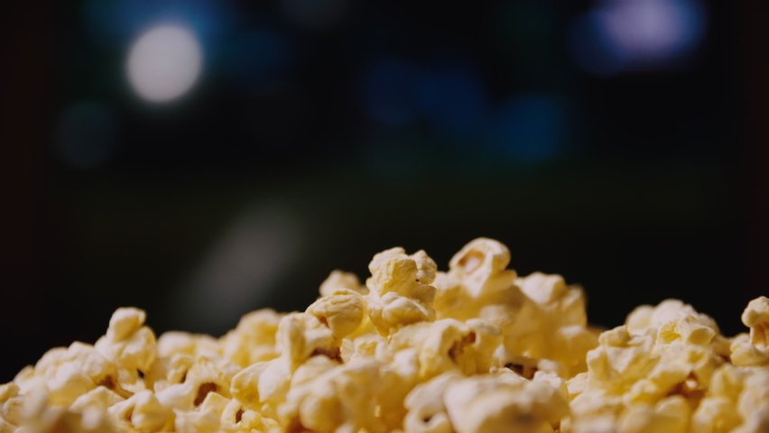Close up of a man eating popcorn while watching a movie in the living room. Royalty-Free Stock Footage #1070344375