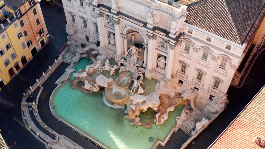 Aerial view of the Trevi Fountain or Fontana di Trevi, baroque landmark in the center city of Rome, Italy. Famous tourist attraction in Roma, Italia seen from drone flying in the sky | Shutterstock HD Video #1070346094