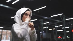 Muslim female boxer in a sports hijab is engaged in boxing, an Arab woman is doing exercises. sports in Islamic countries, concepts of women's rights - Powered by Shutterstock - Get 15% off with code: PIKWIZARD15