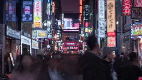Crowds pass through Kabukicho in the Shinjuku district. The area is an entertainment and red-light district. 4K time-lapse, blurred logos