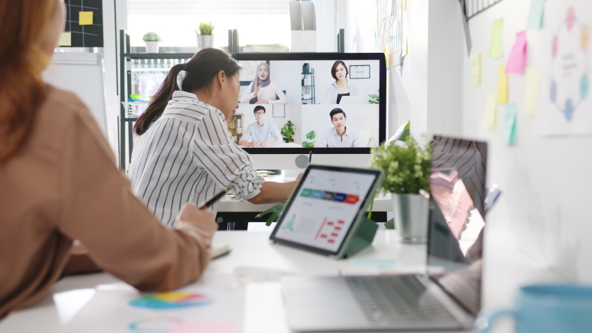 Asia businesspeople using desktop talk to colleagues discussing business brainstorm about plan in video call meeting in new normal office. Lifestyle social distancing and work after corona virus. | Shutterstock HD Video #1070365708
