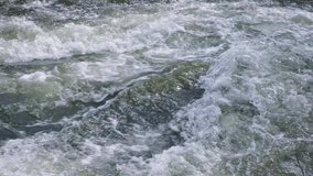 Mountain river water flow in powerful waterfall, video background. Fast stream of water close-up.