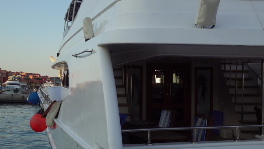 Hurghada port with luxury yachts on colorful Marina promenade street from Red Sea and El Mina mosque in the background