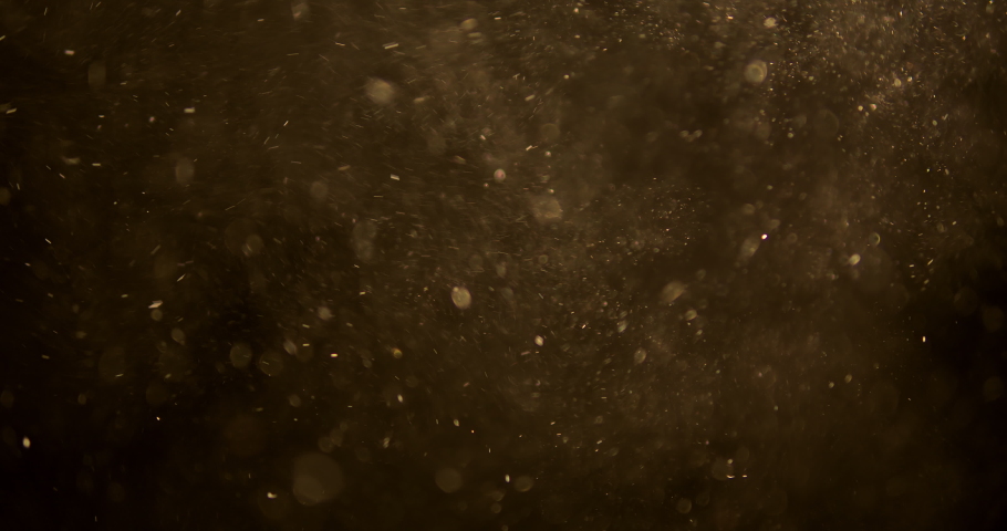 Golden glitter background in slow motion.  real dust particles floating in the air.  Universe gold dust with stars on black background. | Shutterstock HD Video #1070383726