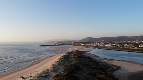 DRONE AERIAL PAN SHOT: The Northern Litoral Natural Park in Ofir, Fao, Esposende, Portugal at sunset. The two sides of Restinga de Ofir. One facing the ocean, the other the estuary of Cávado River.