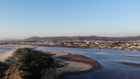 DRONE AERIAL PAN SHOT: The Northern Litoral Natural Park in Ofir, Fao, Esposende, Portugal at sunset. The two sides of Restinga de Ofir. One facing the ocean, the other the estuary of Cávado River.