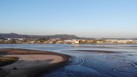 DRONE AERIAL FOOTAGE: Northern Litoral Natural Park in Ofir, Fao, Esposende, Portugal at sunset. The two sides of Restinga de Ofir. One facing the ocean, the other the estuary of Cávado River.