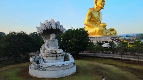 4k Naga Buddha statue. Pan around a Seven-headed king cobra sheltering the Buddha while meditating, Mucilanda. Khao Yai National Park in Thailand. Sunrise glares. Golden image of Luang Phor Thuat