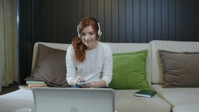 Happy Young Lady Student Wear Headset Communicating By Conference Call Speak Looking At Computer At Home Office, Video Chat Job Interview Or Distance Language Course Class With Online Teacher Concept
