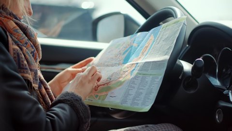 Car Traveling Sitting On Auto Looking Town Plan On Navigation Map For Journey. Woman Tourist Looking On City Paper Map And Exploring City Route. Active Lifestyle On Vacation Travel Tourism Adventure