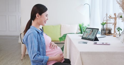 technology and medicine concept - happy pregnant woman with tablet pc computer having a video call with female doctor at home