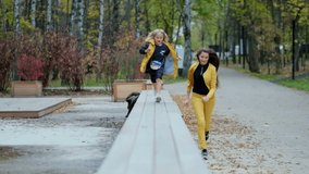 happy time together concept. Happy young mother running after her daughter outdoors in park. video stock footage. Slow motion, soft focus