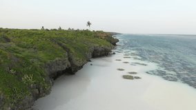 Aerial video: flies over beautiful tropical nature in the lagoon, in the frame of the ocean and green hills, palm trees