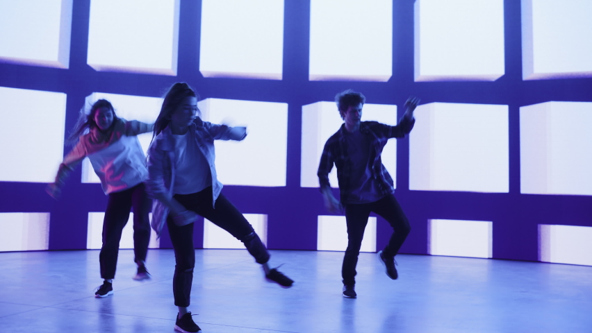 Rotating Footage of Diverse Group of Three Dancers Performing Hip Hop Dance Routine in Front of Big Led Wall Screen with VFX Animation During a Virtual Production in Studio Environment. 105 BPM Song. | Shutterstock HD Video #1070417917