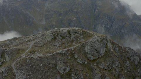Drone shot of two hikers by a summit cross in Austria, Voralberg 14