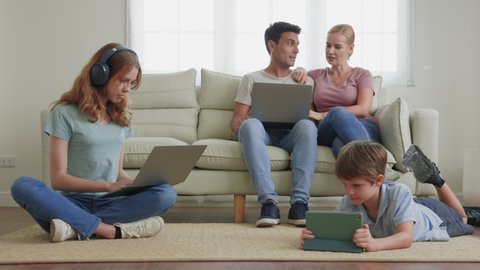 work from home. A parent using a laptop on the couch in the living room. Children use the phone app, search for information, using wifi 5G internet. Family ignore and gadget addiction concept