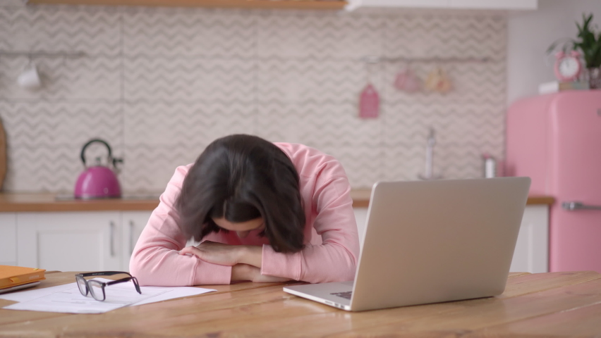 Tired stressed overworked multi ethnic business woman falling asleep at desk, sitting at table with laptop. Depressed unmotivated asian freelancer lying on table, feeling boredom working from home | Shutterstock HD Video #1070428192