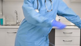 Positive female doctor dancing floss dance in hospital, celebrating the end of coronavirus pandemic. High quality 4k footage.