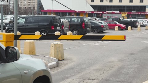 Russia, St.Petersburg, 08 April 2021: The car approaches a barrier before huge shopping center, the barrier opens and the car passes on a parking, the barrier is closed, cloudy weather, a yellow color