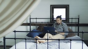 Young handsome man working on a laptop while lying in bed.  - Powered by Shutterstock - Get 15% off with code: PIKWIZARD15