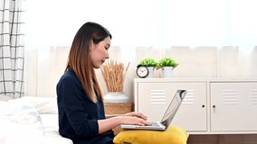 An Asian woman using a laptop at the playroom Work from home based on the stay-at-home concept to stop the coronavirus epidemic, maintain social distance.