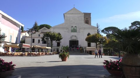 Tourists in Duomo square in Ravello of Amalfi coast visiting cathedral, some sitting in the outdoor cafe.