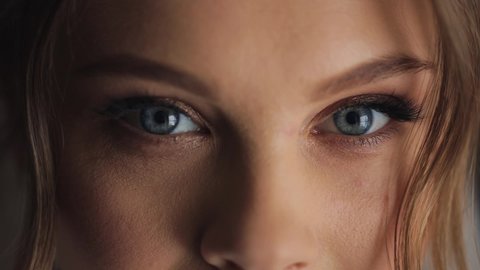 Young beautiful caucasian woman opens blue eyes close up macro human iris natural beauty