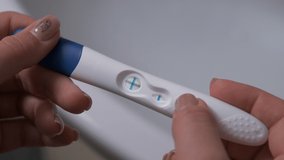Woman holding positive a pregnancy test in her hand. closeup shot of the test in her hands - Powered by Shutterstock - Get 15% off with code: PIKWIZARD15